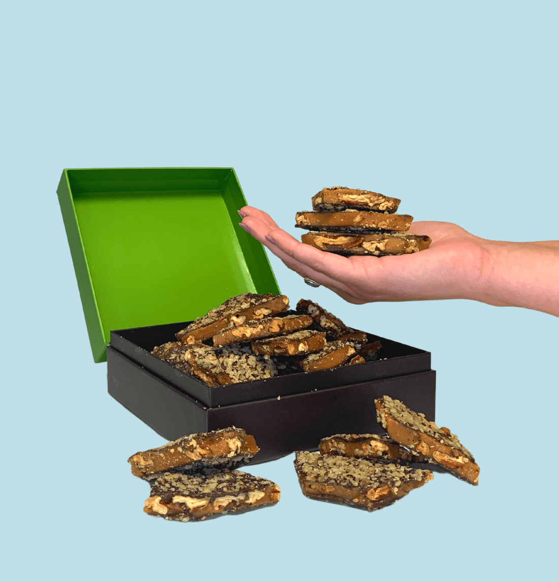 Handful of toffee over a box full of toffee